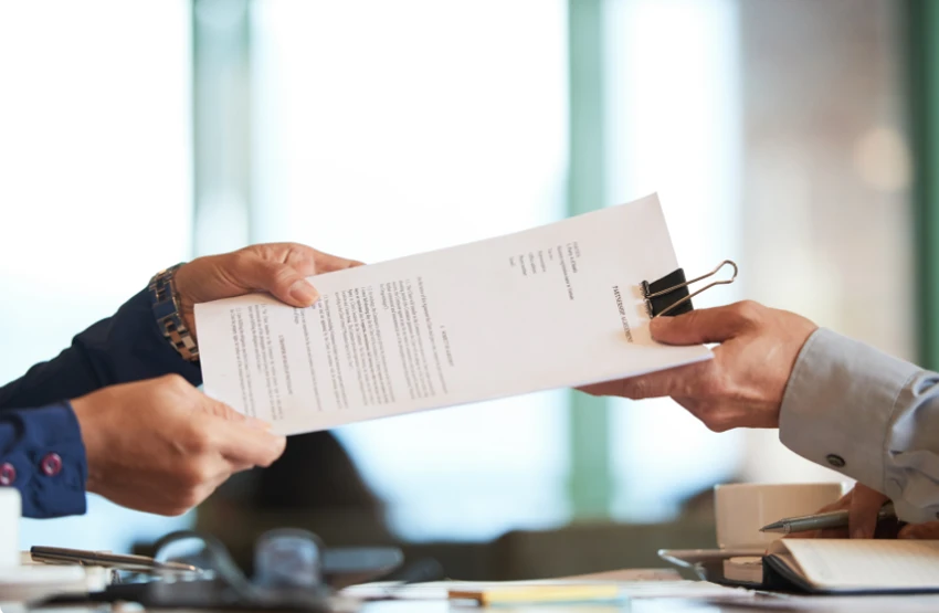 dos personas firmando un contrato escrito